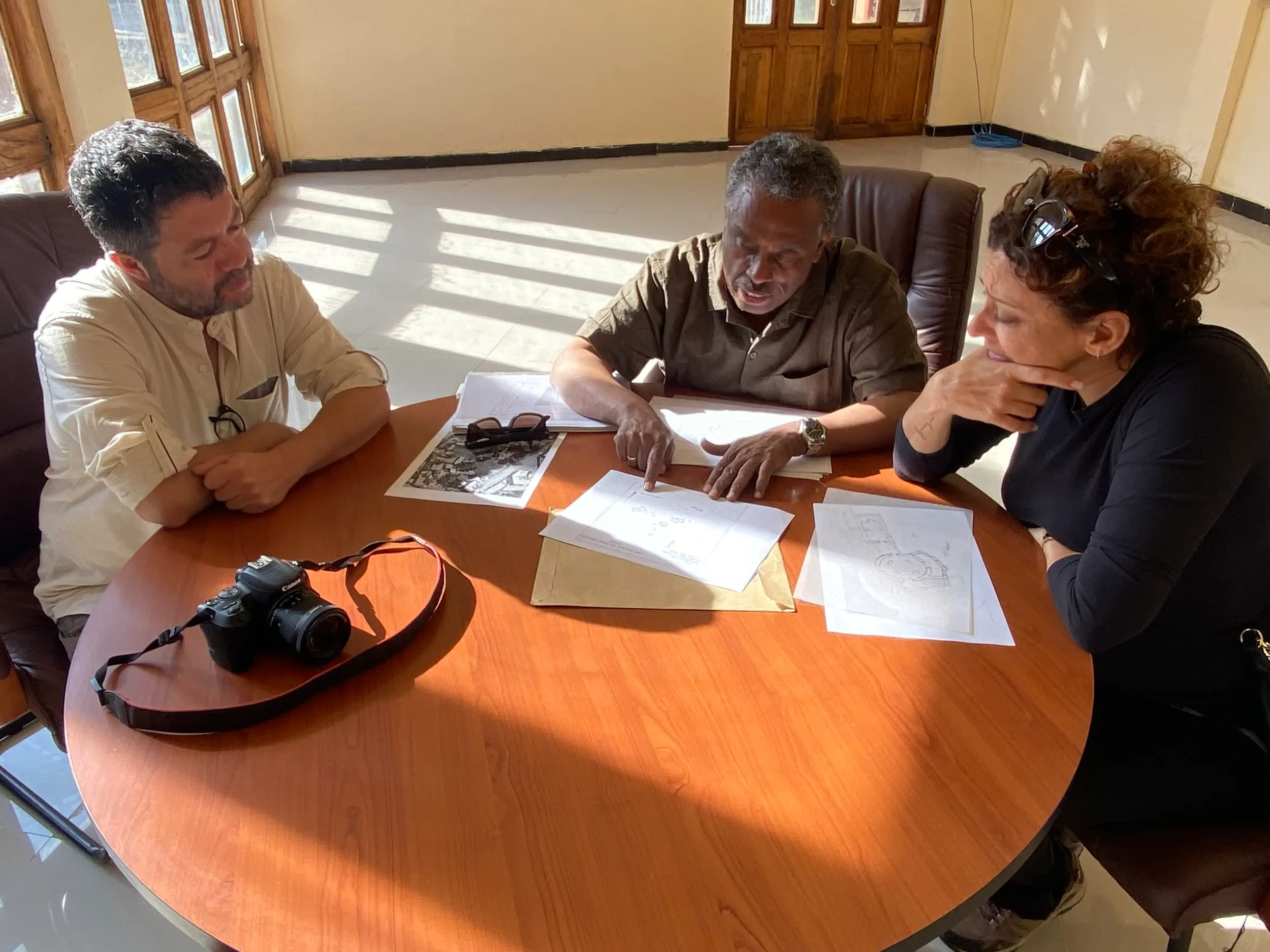 Cinzia working with a team around a table on a cultural project