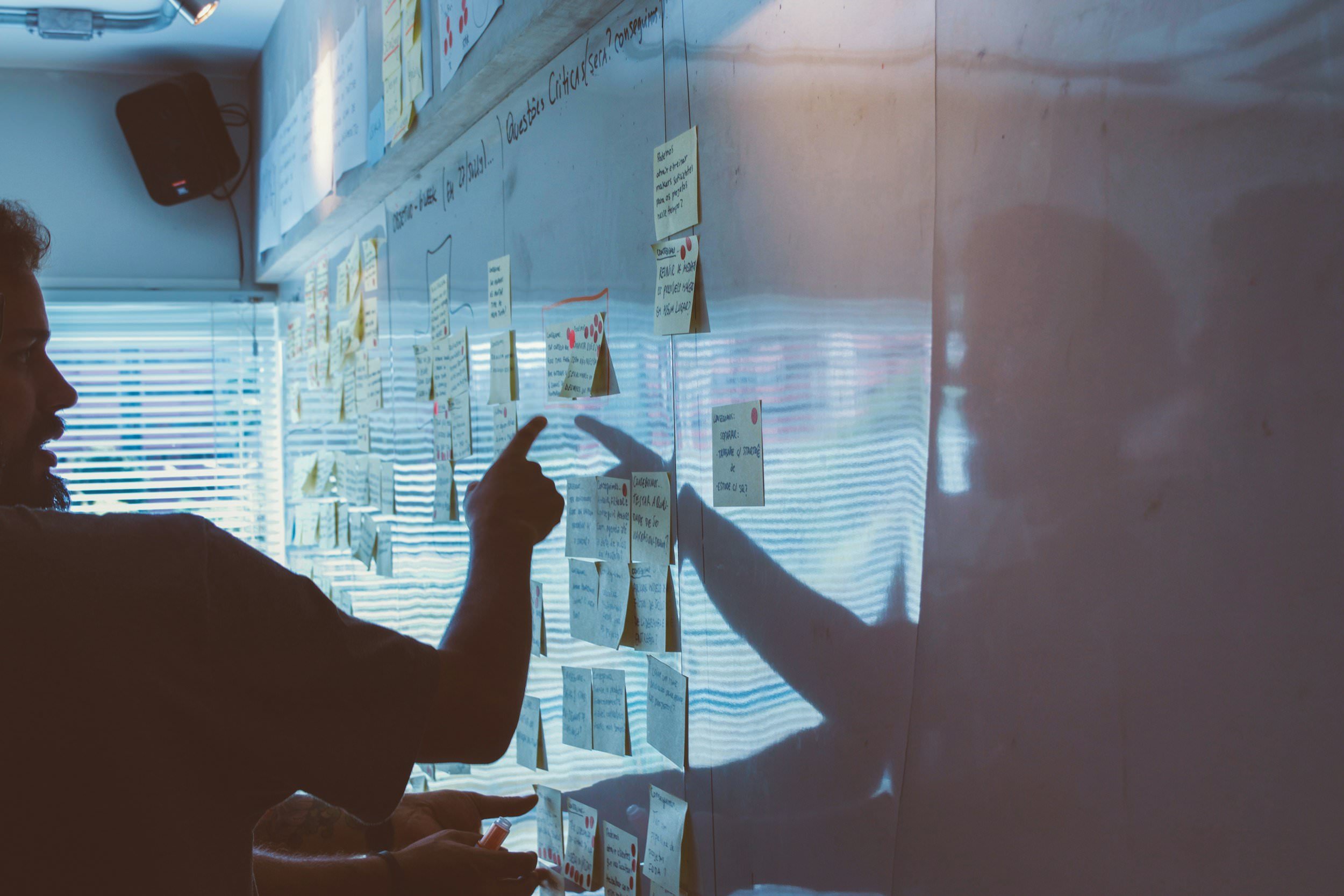 Planning wall covered in post-its and printed schedules — a working project-management environment
